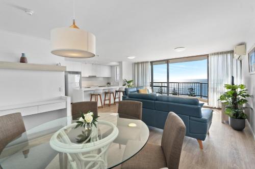 a living room with a blue couch and a table at Seaview Resort in Mooloolaba