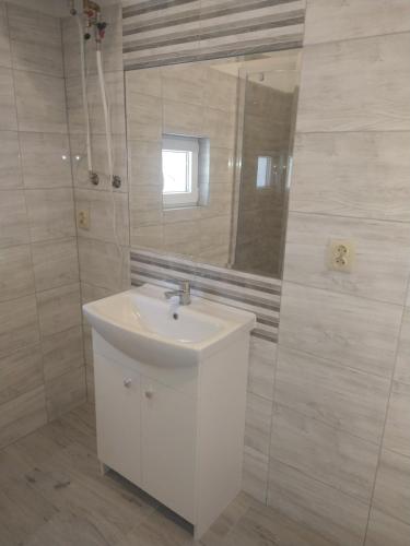 a white bathroom with a sink and a mirror at Ranczo u Jarka in Jeżyce