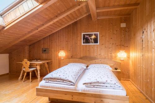 a bedroom with a bed in a wooden wall at Ferienwohnung Aster Nusserhof in Avelengo