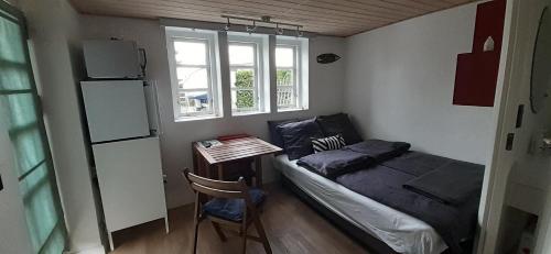 een slaapkamer met een bed, een tafel en een raam bij Cozy tiny room, mini kitchen and bathroom in Otterup