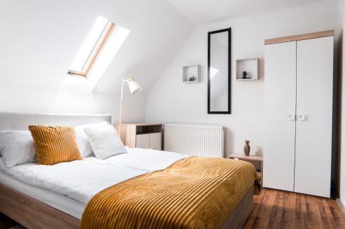 a bedroom with a bed with a yellow blanket on it at Imádó Vendégház in Cernatu de Sus