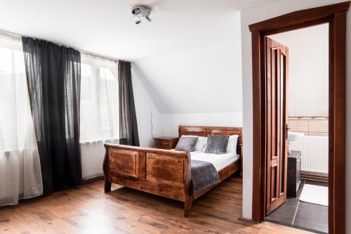 - une chambre avec un lit en bois et un miroir dans l'établissement Imádó Vendégház, à Cernatu de Sus
