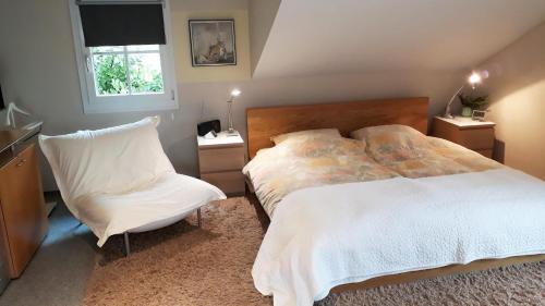 1 dormitorio con 1 cama y 1 silla en Ferienwohnung CHRIS, en Constanza