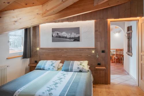 a bedroom with a bed with a wooden wall at Cèsa Castlunger in Canazei