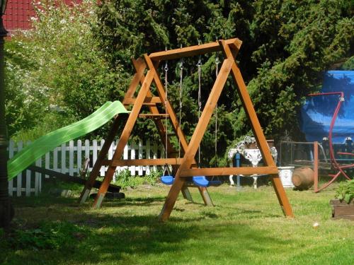 a wooden swing set in a yard at Ferienwohnungen Behling am Schufutsberg in Liepe