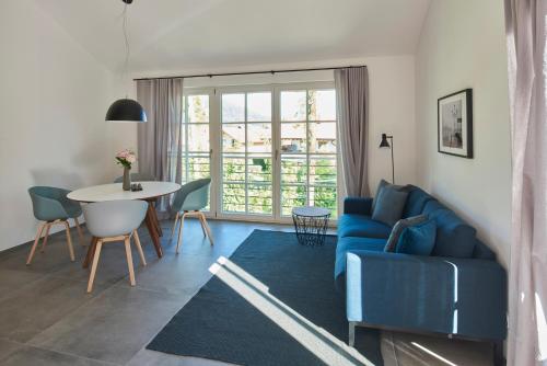 a living room with a blue couch and a table at Ferienwohnungen am Lochbach in Aschau im Chiemgau