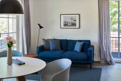 a living room with a blue couch and a table at Ferienwohnungen am Lochbach in Aschau im Chiemgau