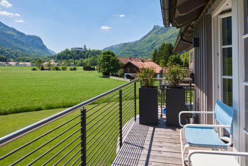 a balcony with chairs and a view of a field at Ferienwohnungen am Lochbach in Aschau im Chiemgau