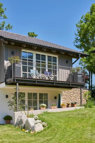 a house with a deck and a balcony at Ferienwohnungen am Lochbach in Aschau im Chiemgau