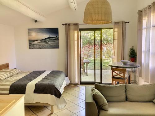 1 dormitorio con cama, sofá y mesa en La belle histoire Gîte Ventoux, en Bédoin