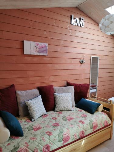 Ce lit se trouve dans une chambre dotée d'un mur rouge. dans l'établissement Au Coeur de la Nature, à Saint-Malo-du-Bois