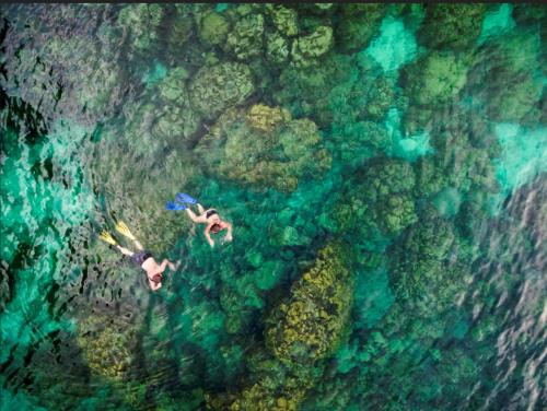 a person swimming in the water near the ocean at Pimalai Resort & Spa in Ko Lanta