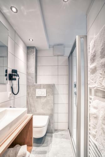 a bathroom with a white toilet and a sink at Apart Gstrein - including Silvretta Premium Summercard in See