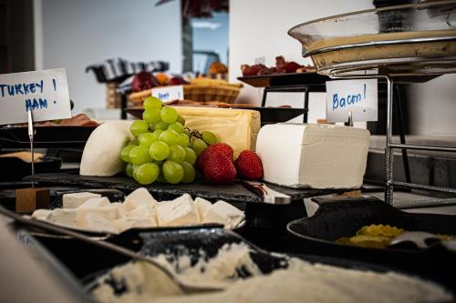 a display of cheese and fruit on a table at SUHA Mina Rashid Hotel Apartments in Dubai