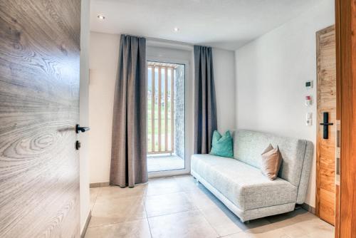 a living room with a chair and a window at Apart Gstrein - including Silvretta Premium Summercard in See