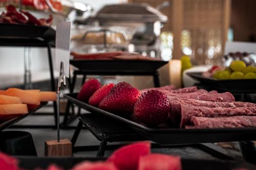 a buffet with meat and other fruits and vegetables at SUHA Mina Rashid Hotel Apartments in Dubai