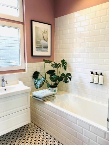a bathroom with a tub and a potted plant at HOMESTEAD Amsterdam in Amsterdam