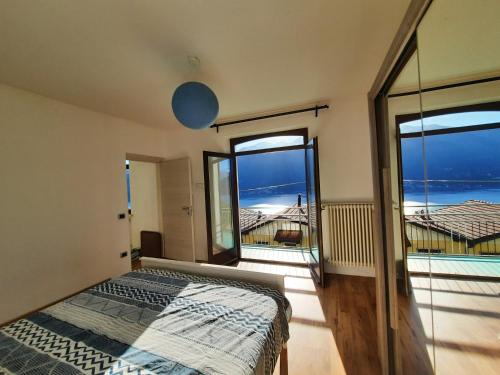 a bedroom with a bed and a view of the ocean at Casa Vacanze - Casa Quattro Luci in Tronzano Lago Maggiore