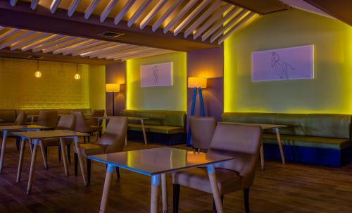 a restaurant with tables and chairs and paintings on the wall at HAMILTON Agadir in Agadir