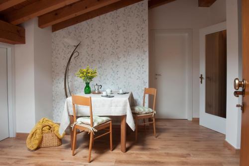 a dining room with a white table and chairs at B&B In Contrá in Selva di Progno