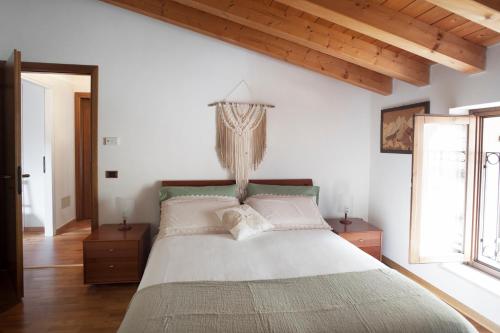 a bedroom with a large bed with a chandelier at B&B In Contrá in Selva di Progno