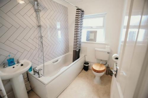 a bathroom with a tub and a toilet and a sink at Quirky bohemian Lake District miners cottage- 6 bd in Millom