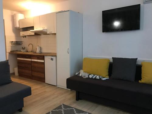 a living room with a couch and a kitchen at Apart - apartament 12 in Okuninka