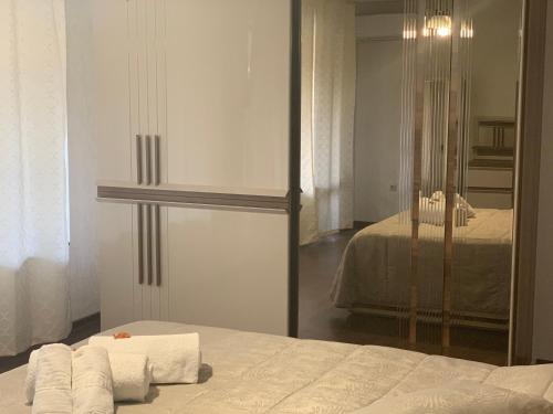 a bedroom with a mirror and a bed with towels at Casafamiglia in Prolesha