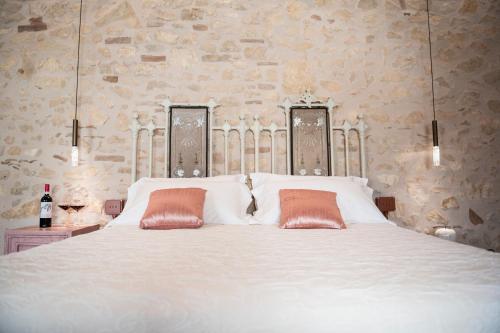 a bedroom with a white bed with two orange pillows at Magari Estates Boutique Hotel in Colognola ai Colli