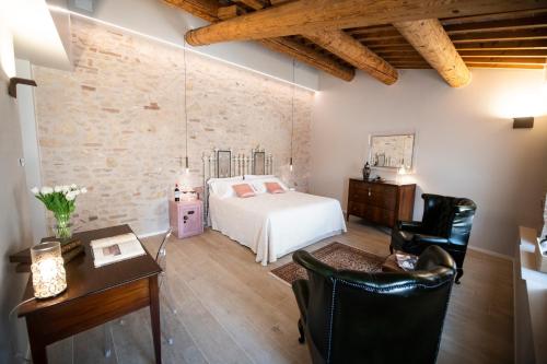 a bedroom with a bed and a desk and chairs at Magari Estates Boutique Hotel in Colognola ai Colli