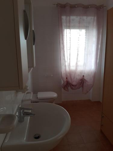 a bathroom with a sink and a toilet and a window at Laura in Vieste