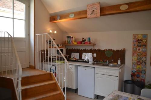 a kitchen with a counter and a staircase in a room at Domaine Maltoff in Coulanges-la-Vineuse
