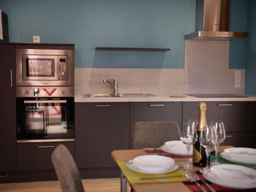 une cuisine avec une table avec des assiettes et des verres à vin dans l'établissement Plage à 50m Appartement Rêves bleus Villa Les Bains de Mers, à Mers-les-Bains