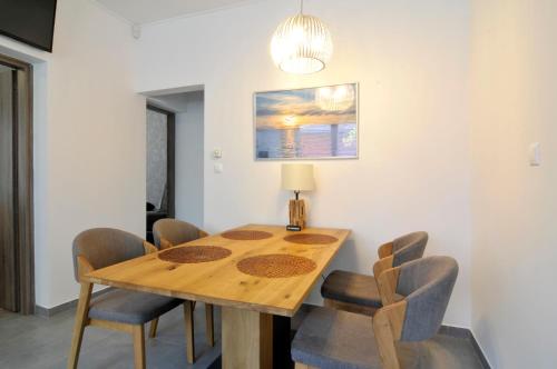 a dining room with a wooden table and chairs at Silver Beach Apartments in Siófok