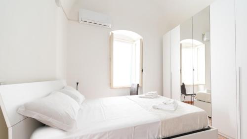 una camera bianca con letto e specchio di Alloggio da Paolina a Castellaneta