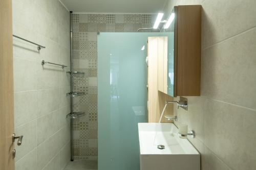 bagno con lavandino e doccia con specchio di George's Apartment a Rethymno