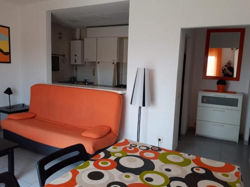 ロザスにあるApartament Roses Costa Bravaのリビングルーム(オレンジ色のソファ付)、キッチンが備わります。