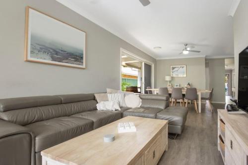 a living room with a couch and a table at Callala Bay Beach House - Wowly Waters - Pet Friendly in Callala Bay