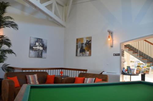 a living room with a pool table and a couch at Hotel et Spa Les Cleunes Oléron in Saint-Trojan-les-Bains