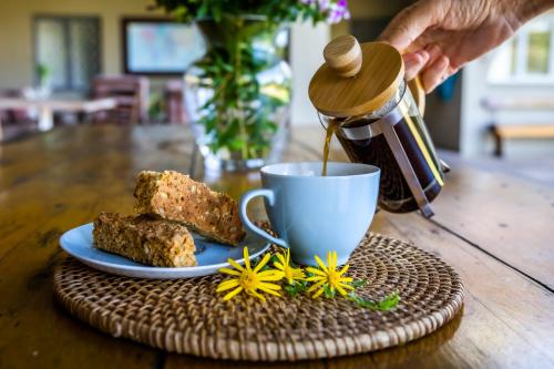 a person is pouring coffee into a cup on a table at Ngoye Lodge in Mtunzini