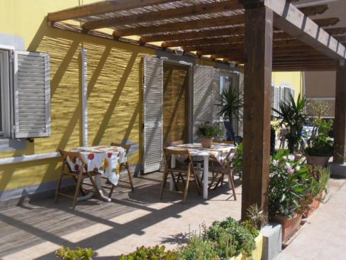 a patio with two tables and chairs under a pergola at Appartamenti Claudia Rio in Rio Marina