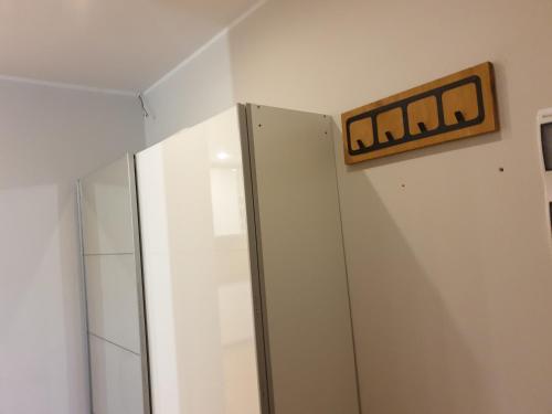 un baño con espejo y un cartel en la pared en Maly apartament w zieleni blisko jeziora, en Środa Wielkopolska