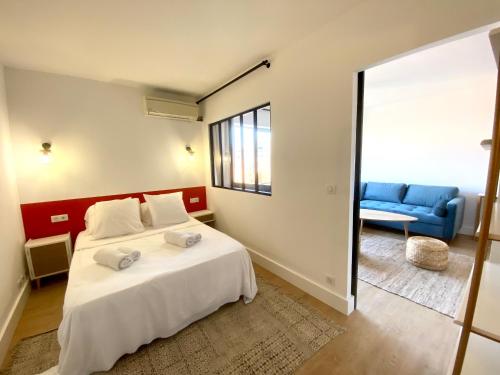 - une chambre avec un lit blanc et un canapé bleu dans l'établissement Superbe T2 équipé proche centre ville Ajaccio avec parking, à Ajaccio