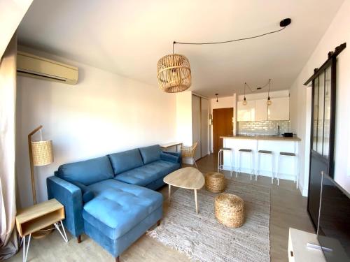 un salon avec un canapé bleu et une cuisine dans l'établissement Superbe T2 équipé proche centre ville Ajaccio avec parking, à Ajaccio