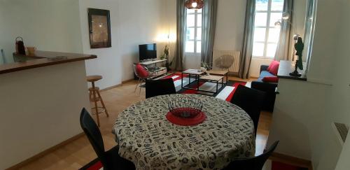 une table à manger et des chaises dans un salon dans l'établissement Burdigala Homes - Appart de la Devise, à Bordeaux