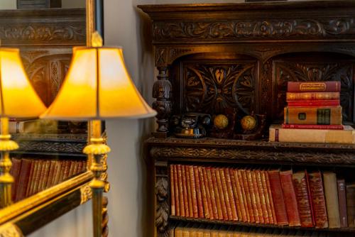 uma lâmpada sentada ao lado de uma estante de livros com livros em Angel and Royal Hotel em Grantham