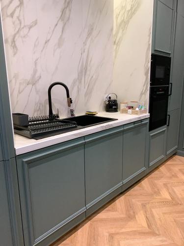 une cuisine avec un évier et un plan de travail dans l'établissement Appartement l'émeraude à Saint Malo Intra-Muros, à Saint-Malo