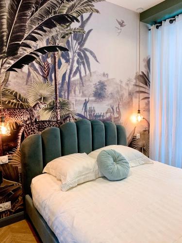 - une chambre dotée d'un lit en touffet bleu et d'une fresque murale dans l'établissement Appartement l'émeraude à Saint Malo Intra-Muros, à Saint-Malo