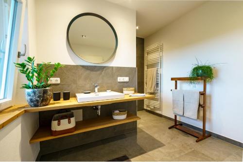 a bathroom with a sink and a mirror at Ferienwohnung Pölzl in Chieming