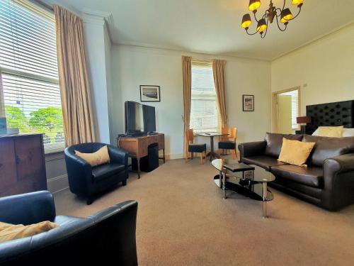 a living room with couches and chairs and a tv at Rowntree Lodge in Scarborough